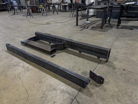IA-JB-60T boom sections in bare steel during fabrication at the Iron Attach shop in Post Falls