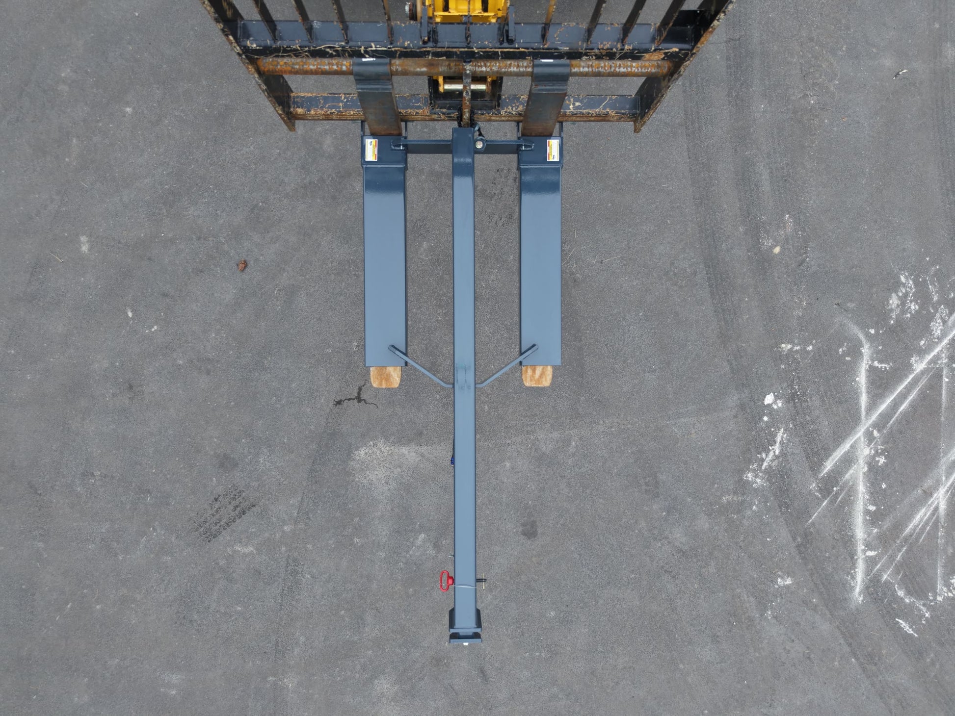 Top-down view of IA-JB-60T fork pockets seated on telehandler forks with retaining pins